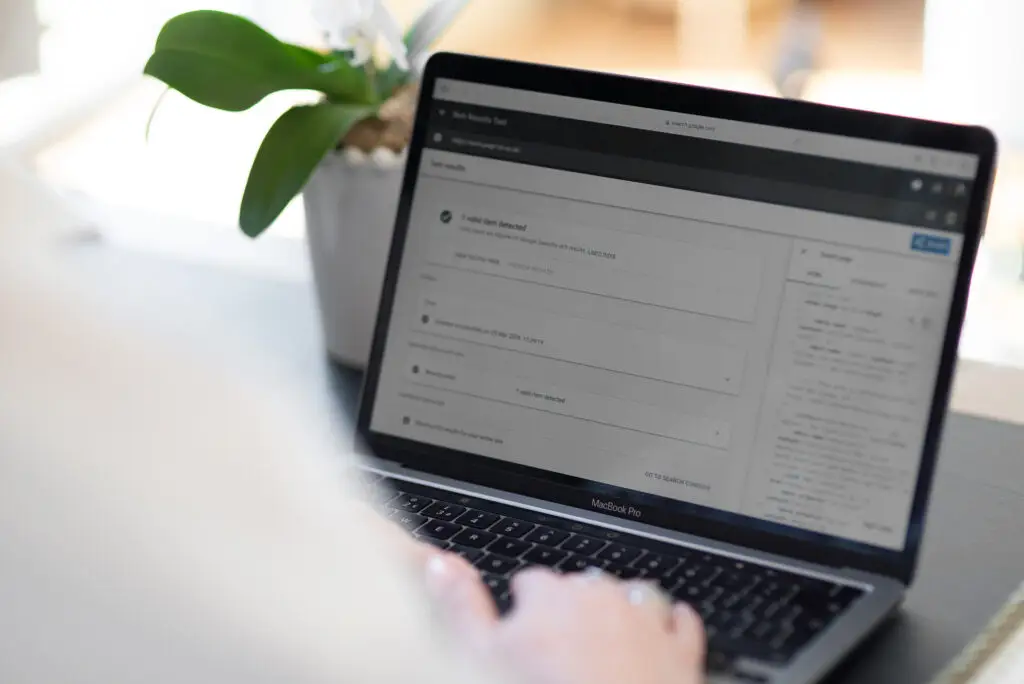 Google Search Console open on the screen of a MacBook with a person typing in the foreground
