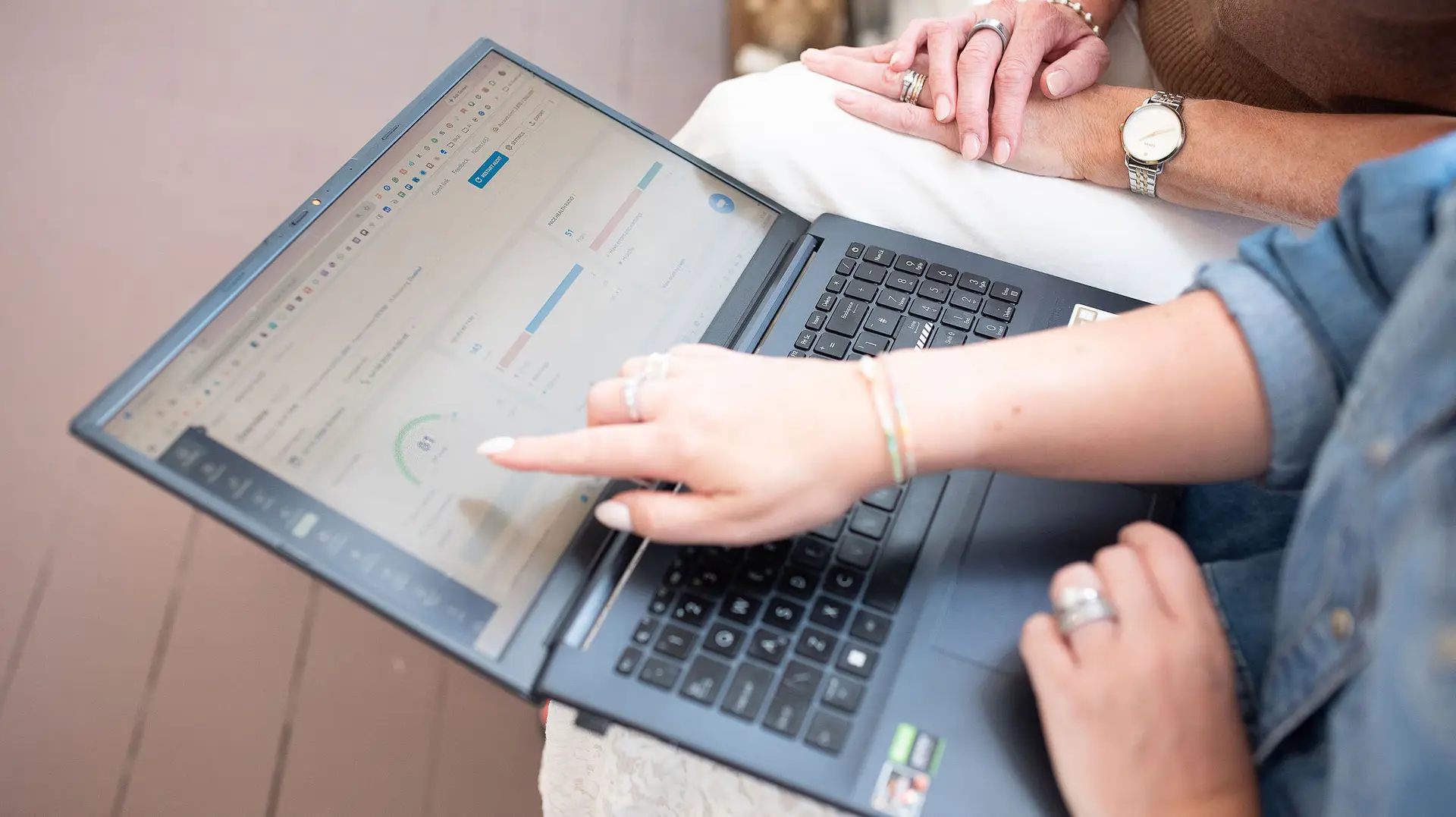 two people looking at laptop screen analysing data