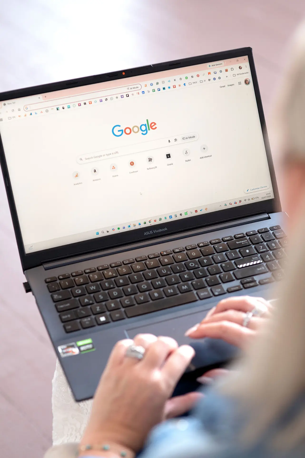 person using google on a laptop with hands on the trackpad